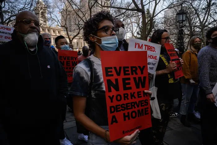 A protester holds a sign stating that every New Yorker deserves a home.